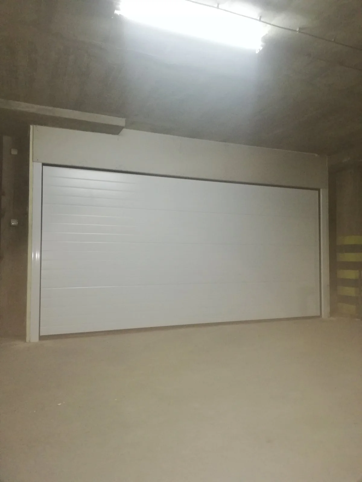 Bela garažna vrata iznutra, pogled iz podzemne garaže